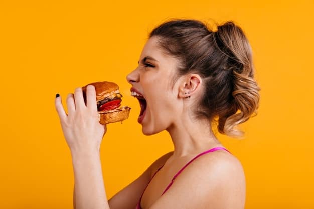 donna che mangia nervosamente un hamburger